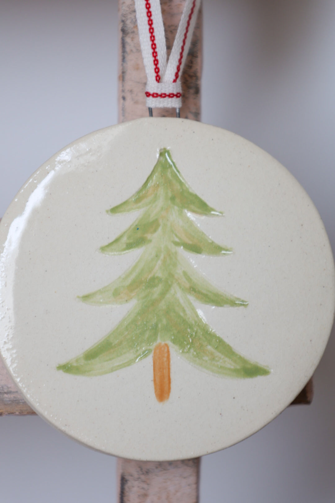 Ceramic ornament with a green tree design on a white background.Handmade by Sea Bramble Ceramics.