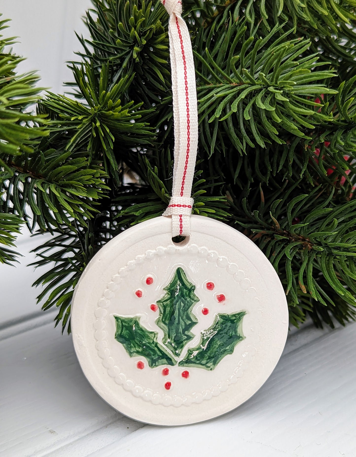 Circular Ceramic Christmas tree decoration with Holly motif
