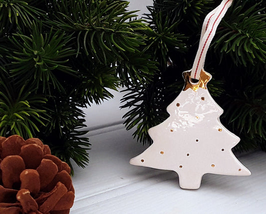 White ceramic Christmas tree ornament decorated with gold dots and topped with a gold star