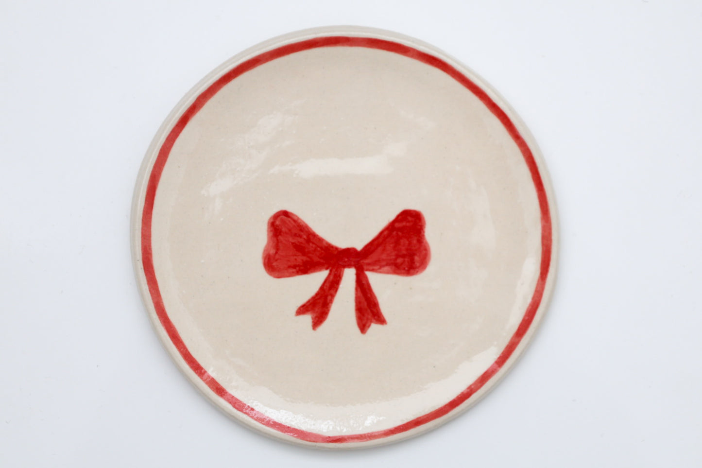 Ceramic stoneware plates with a Christmas bow design. Handmade, hand-painted. Sea Bramble Ceramics. Decorative plates.