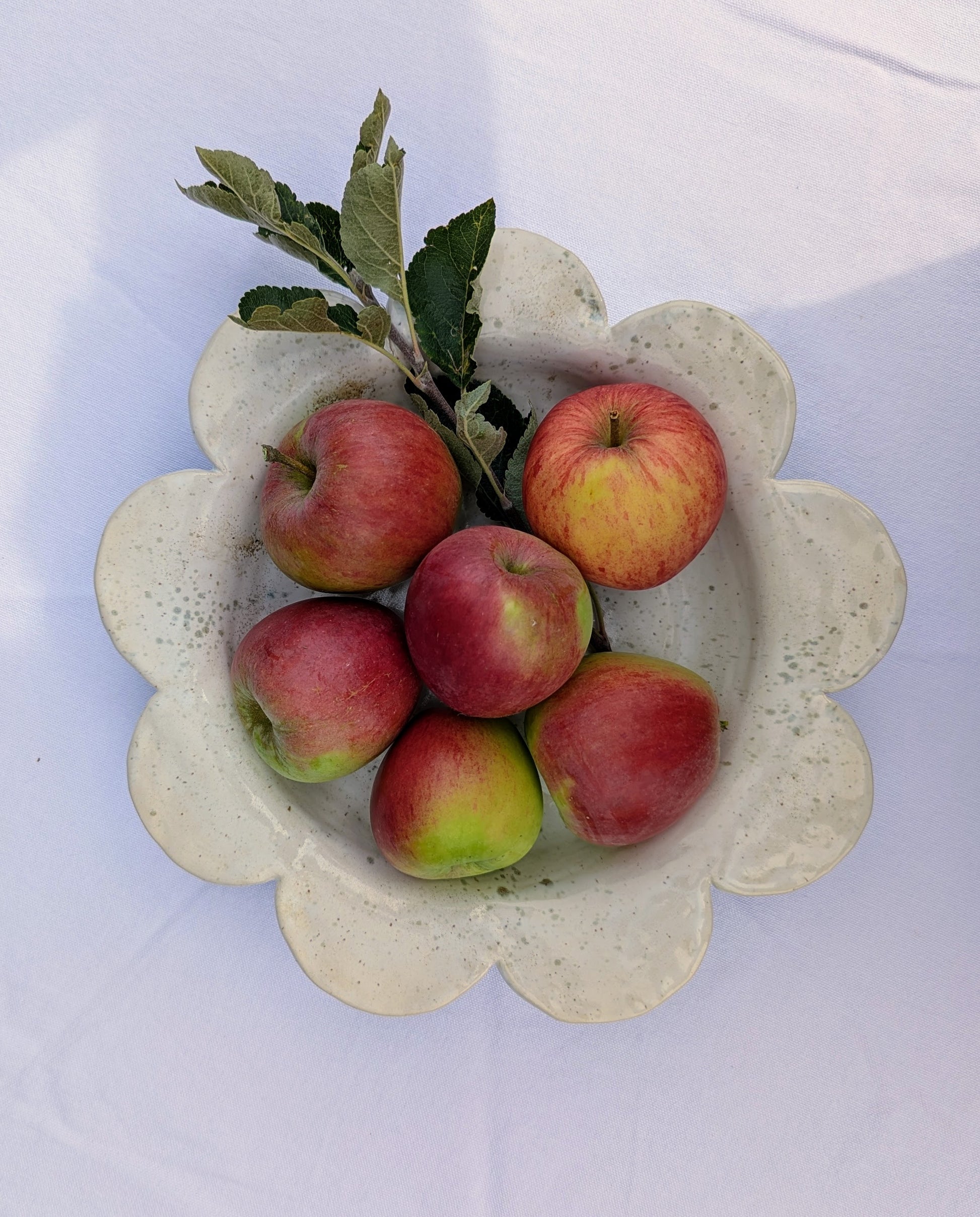 Decorative stone bowl with red apples on a white background. Designed and handmade exclusively by Sea Bramble Ceramics.